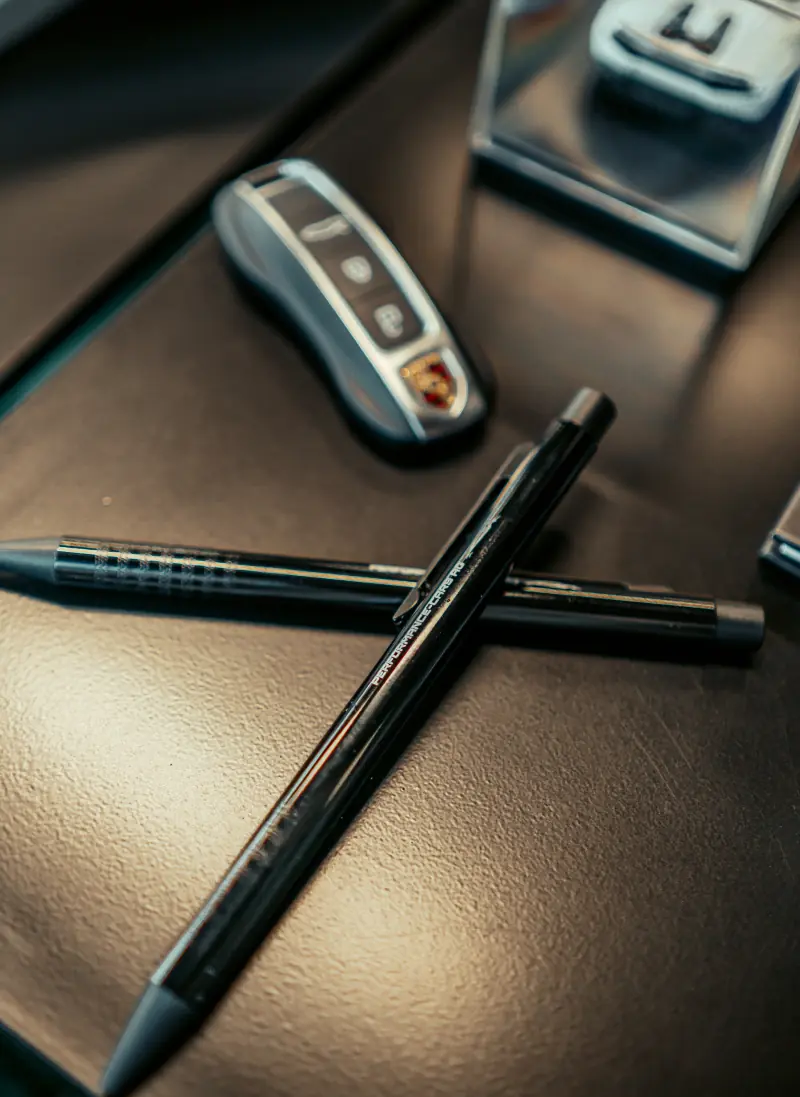 Stift und Fahrzeugschlüssel auf dem Ledertisch